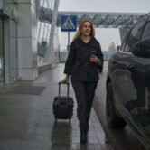 woman-in-coat-going-along-street-with-suitcase-nea-2024-10-18-09-33-47-utc woman-in-coat-going-along-street-with-suitcase-nea-2024-10-18-09-33-47-utc